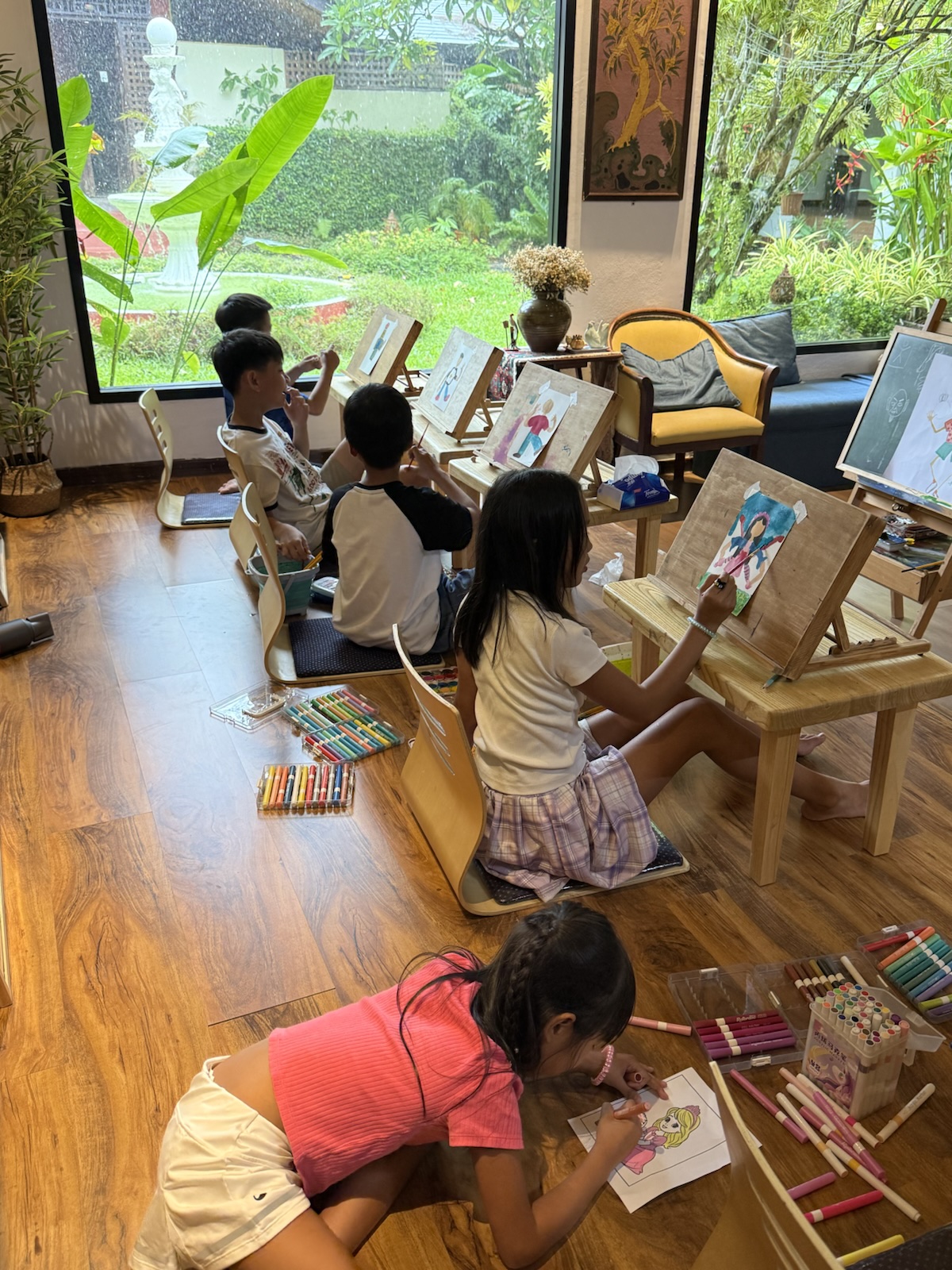 Children drawing together in Pimalai Spa’s garden-facing activity room